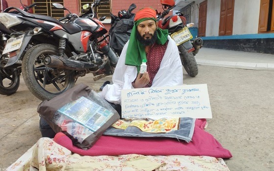 শরীরে কাফনের কাপড় জড়িয়ে বিষের বোতল নিয়ে সাংবাদিকের অবস্থান