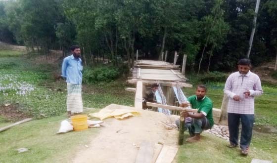 নিজেরাই কাঠের ব্রীজটি মেরামত করে চলাফেরা করছে